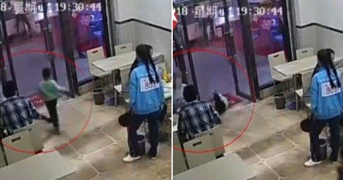 Une femme enceinte fait croque-en-jambe à un enfant qui court dans un restaurant.