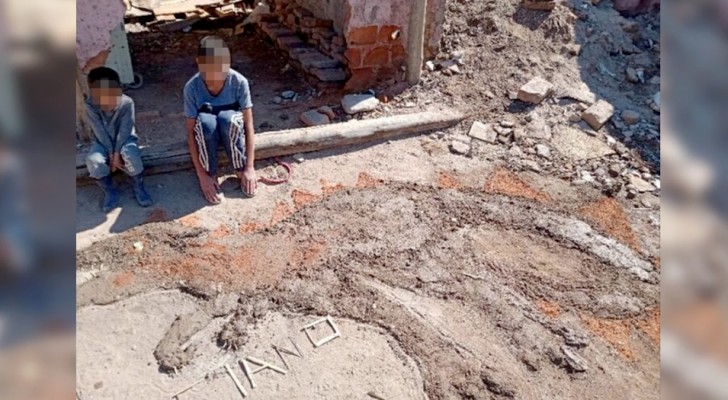 Il n’a pas de papier et de feutres à la maison : un enfant pauvre fait un dessin avec de la terre pour son devoir scolaire